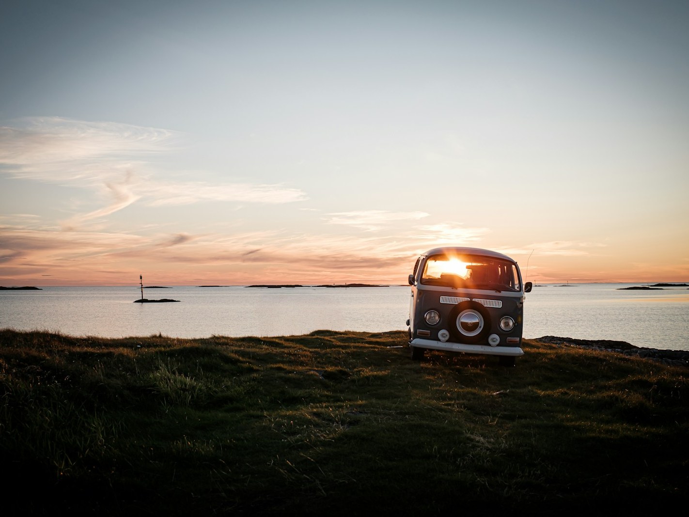 Camper aan het strand bij zonsondergang